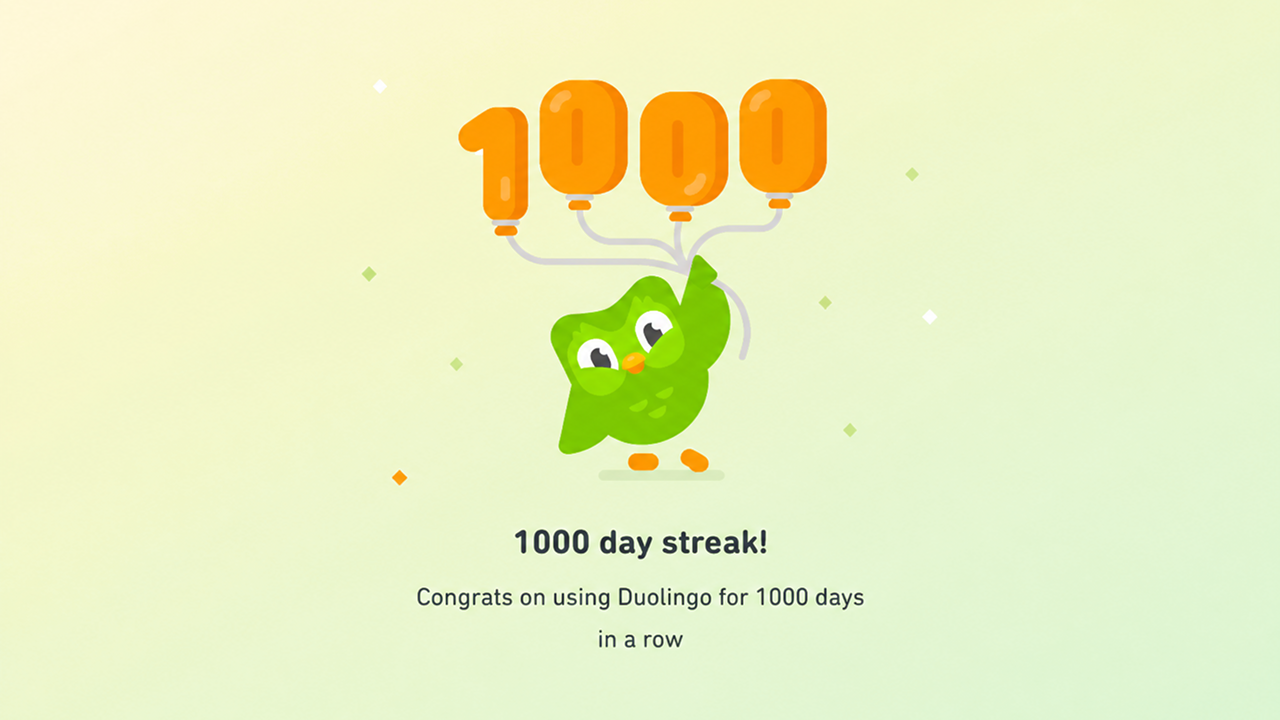 Duolingo's '1000 day streak!' celebration screen, Duo the owl holding orange balloons spelling 1000.